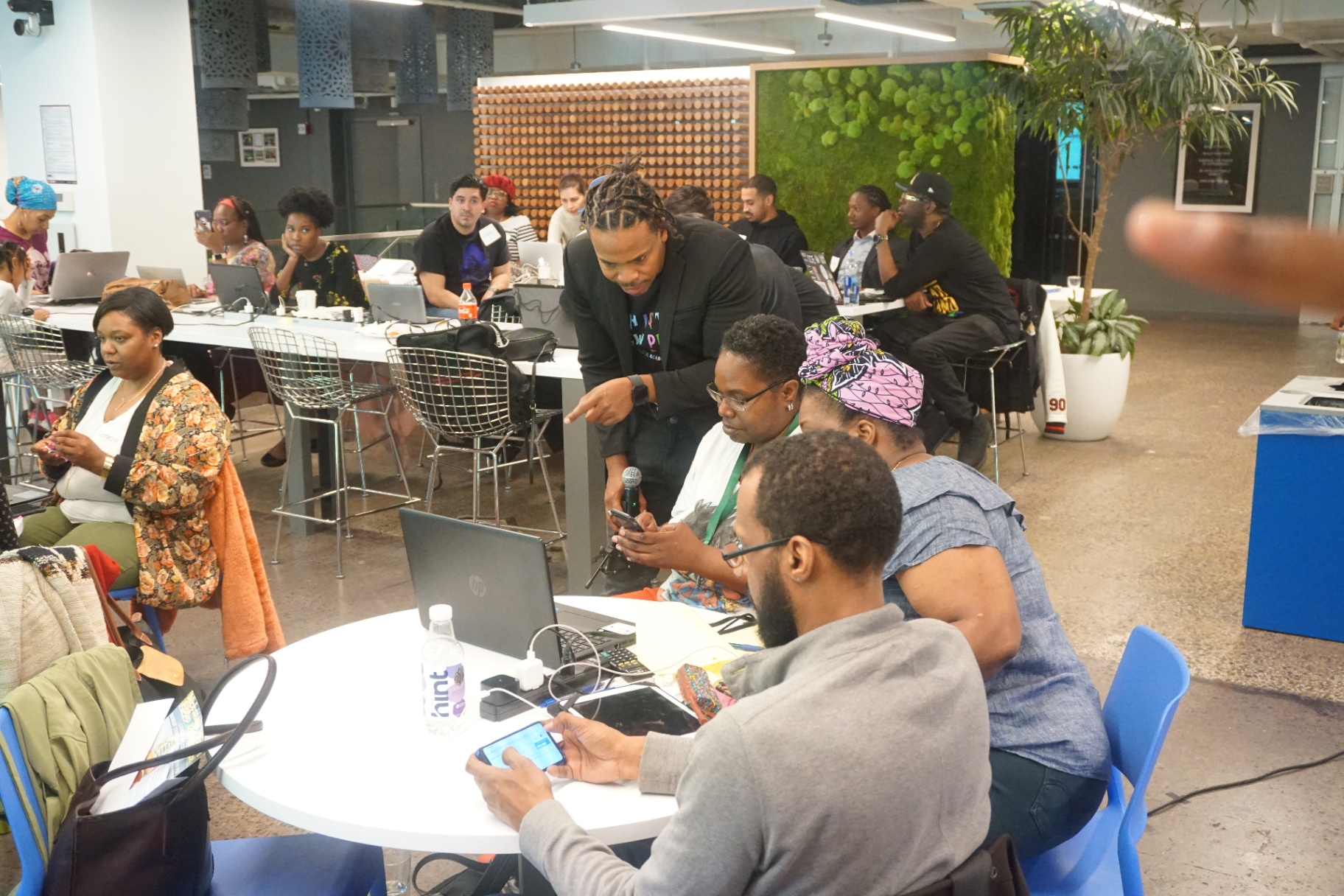 Antoine teaching adults in a coworking space, mic in hand